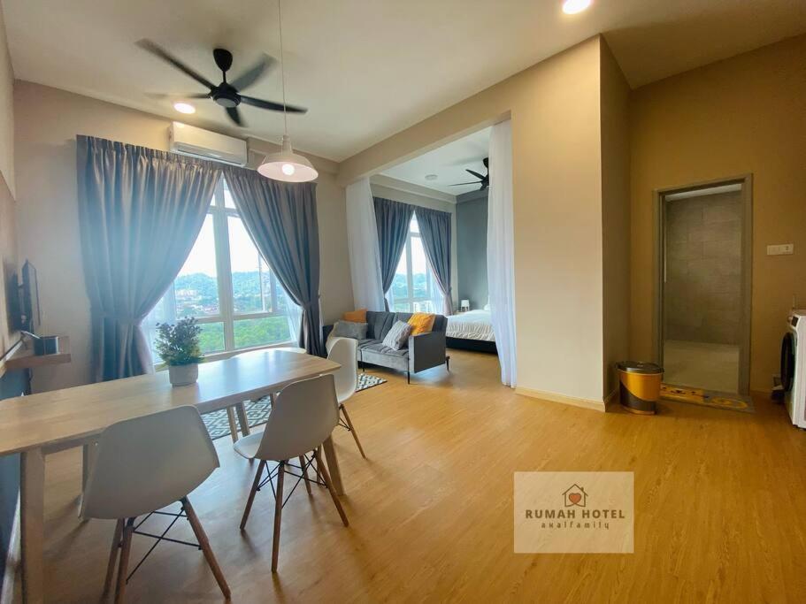 ein Wohnzimmer mit einem Tisch und Stühlen sowie ein Wohnzimmer in der Unterkunft Mahkota Valley (Rumah Hotel) in Kuantan