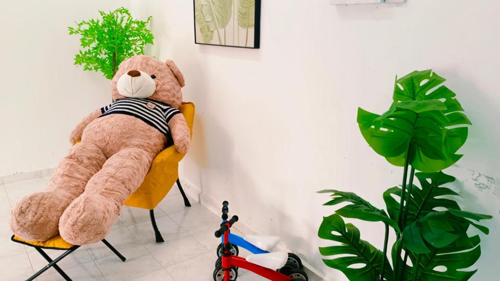 een teddybeer op een stoel in een kamer bij 322 Kulai Tmn Bersatu 4BR 10pax Smart Tv near JPO in Kulai