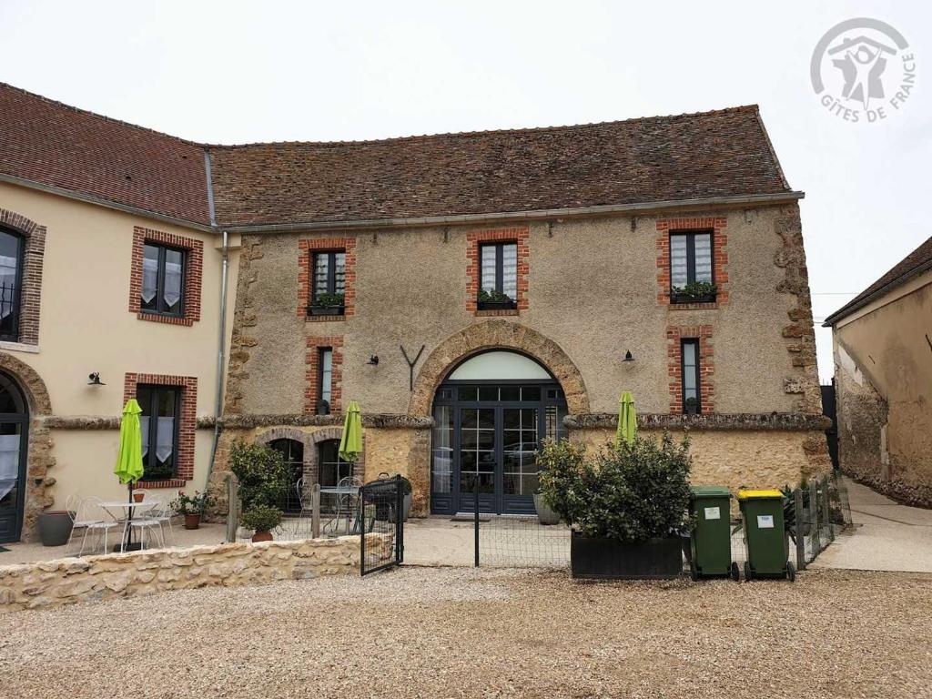 un gran edificio de piedra con un arco delante de él en Gîte Mareil-le-Guyon, 5 pièces, 9 personnes - FR-1-527-41, 