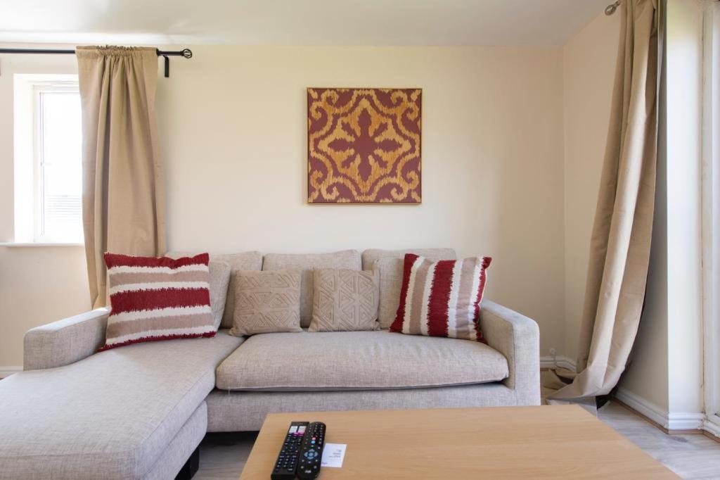 ein Wohnzimmer mit einem Sofa und einem Tisch in der Unterkunft Modern 2 bed apartment 4 separate beds in Thamesmead in Thamesmead