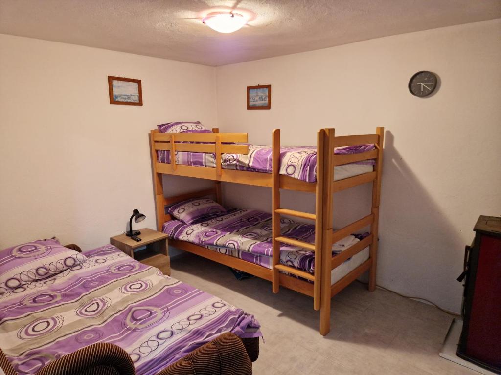 two bunk beds in a room with purple sheets at Zavojsko jezero - kuća Mitić in Pirot