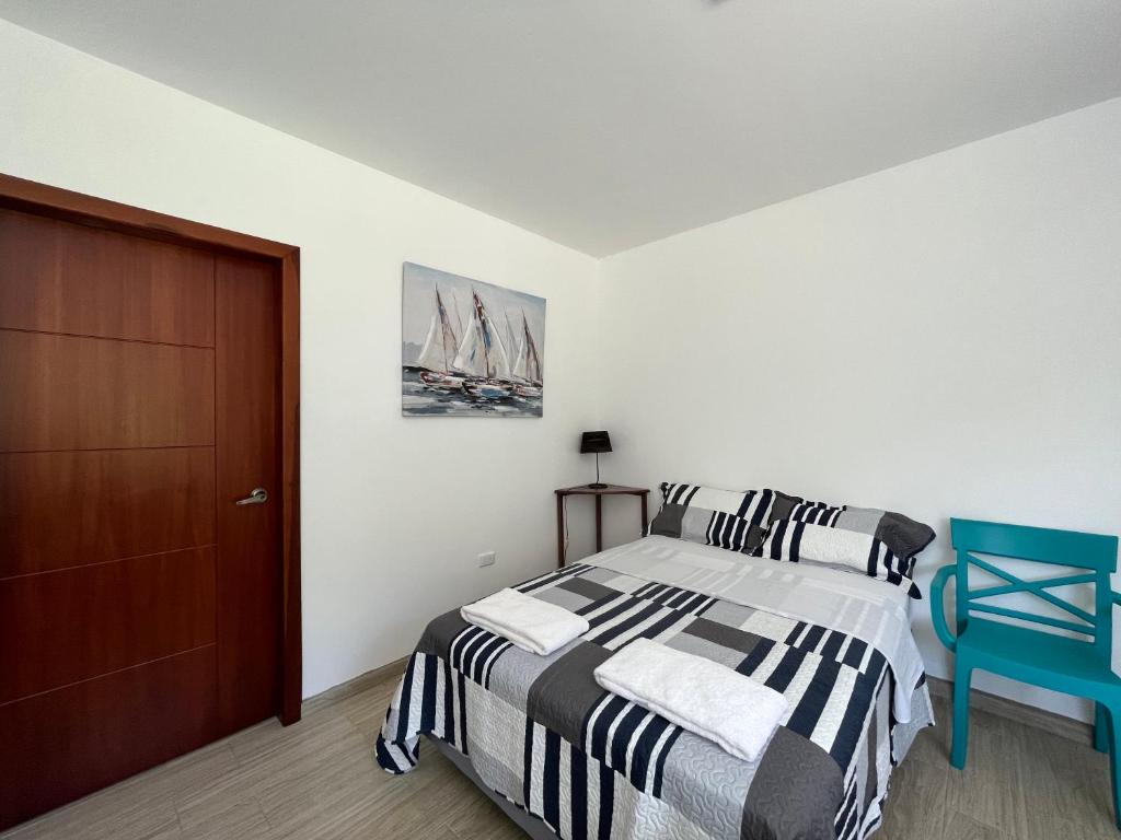 a bedroom with a bed and a blue chair at Brand new Holiday Villa - 3 bedroom 4 bathroom in Baños