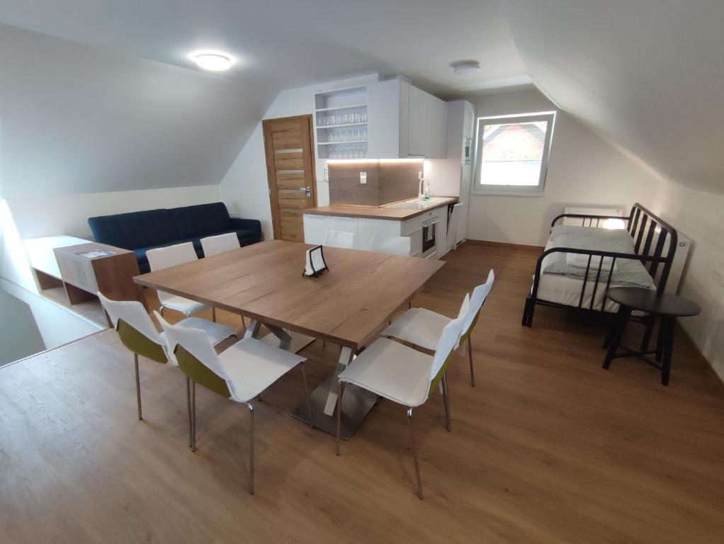 a kitchen and dining room with a wooden table and chairs at apartmánový dom rodiny BÖJTÖS in Virthova Pustatina