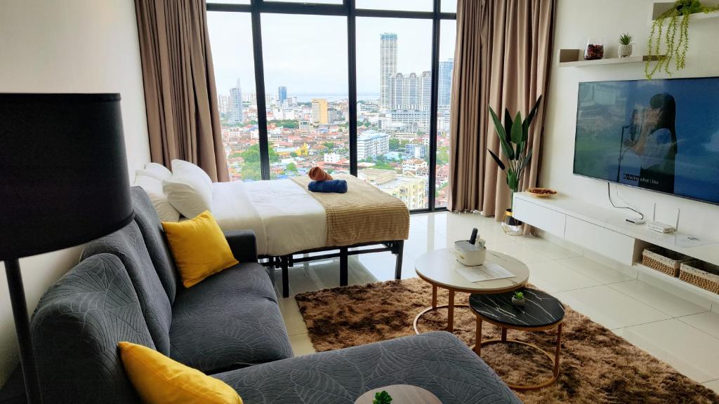 uma sala de estar com um sofá e uma cama com uma grande janela em SkyPool 2BR 9pax Premium Suite@Beacon @Georgetown @Penang em George Town