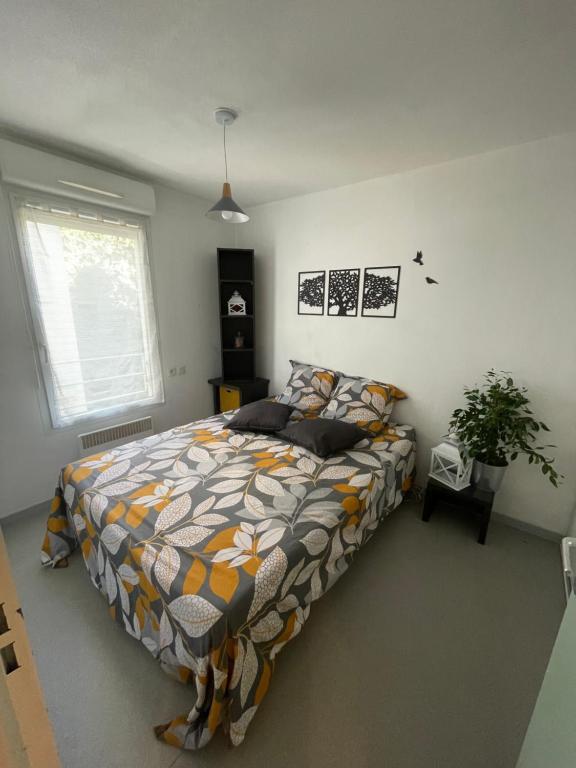 a bedroom with a bed with a colorful comforter at Cosy arena in Nîmes