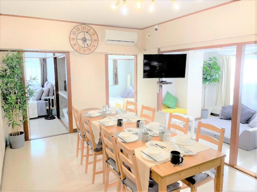 uma sala de jantar com uma mesa longa e cadeiras em くるみん-Kurumin501- em Kurume