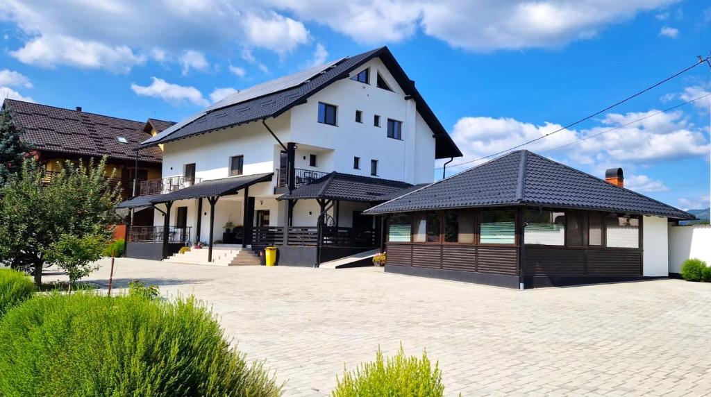 a white building with a black roof at Bukovina Blue in Mănăstirea Humorului