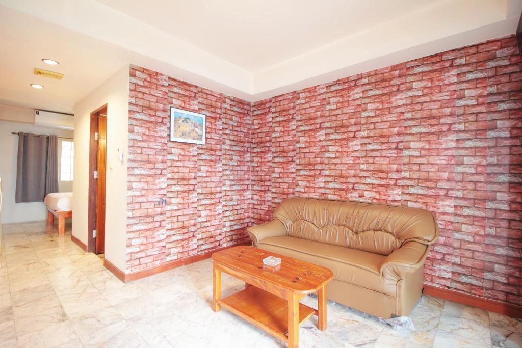 a living room with a brick wall and a couch at 21 hotel in Pattaya Central