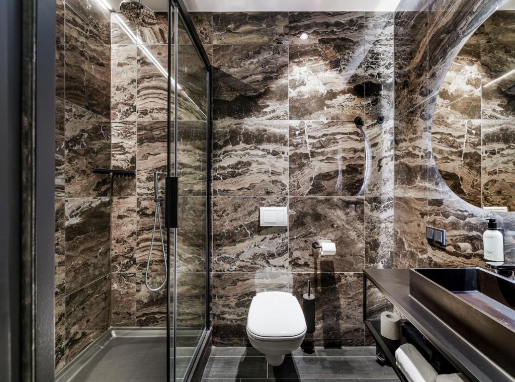 een badkamer met een toilet en een douche bij Le Marin Hotel Rotterdam City - Handwritten Collection in Rotterdam