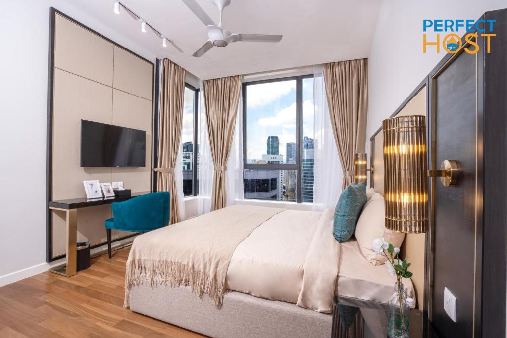 een slaapkamer met een bed en een bureau met een televisie bij Pavilion Ceylon Hill Suites, Bukit Bintang in Kuala Lumpur