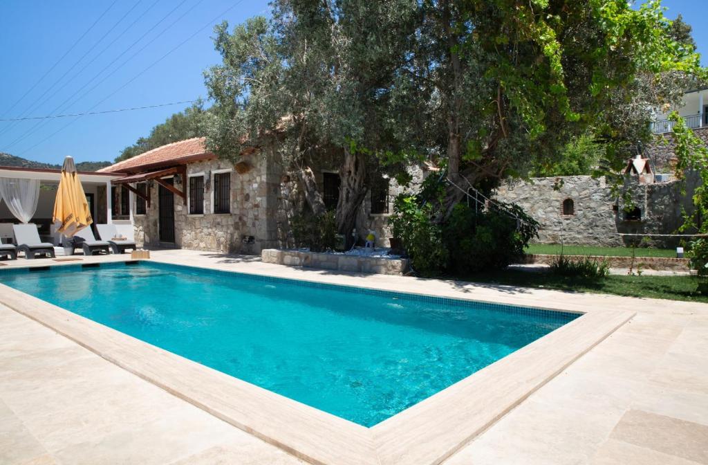 a swimming pool in front of a house at Stone House w Private Pool and Garden in Bodrum in Ortakent