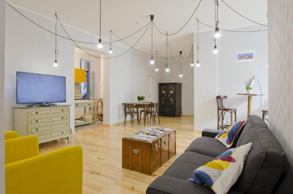 ein Wohnzimmer mit einem Sofa und einem TV in der Unterkunft Feel Lisbon B&B in Lissabon