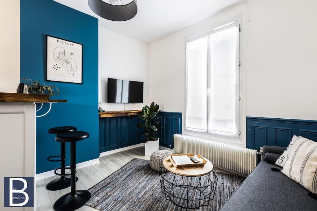 sala de estar con pared de acento azul en Le Bataillon - Confort en Compiègne