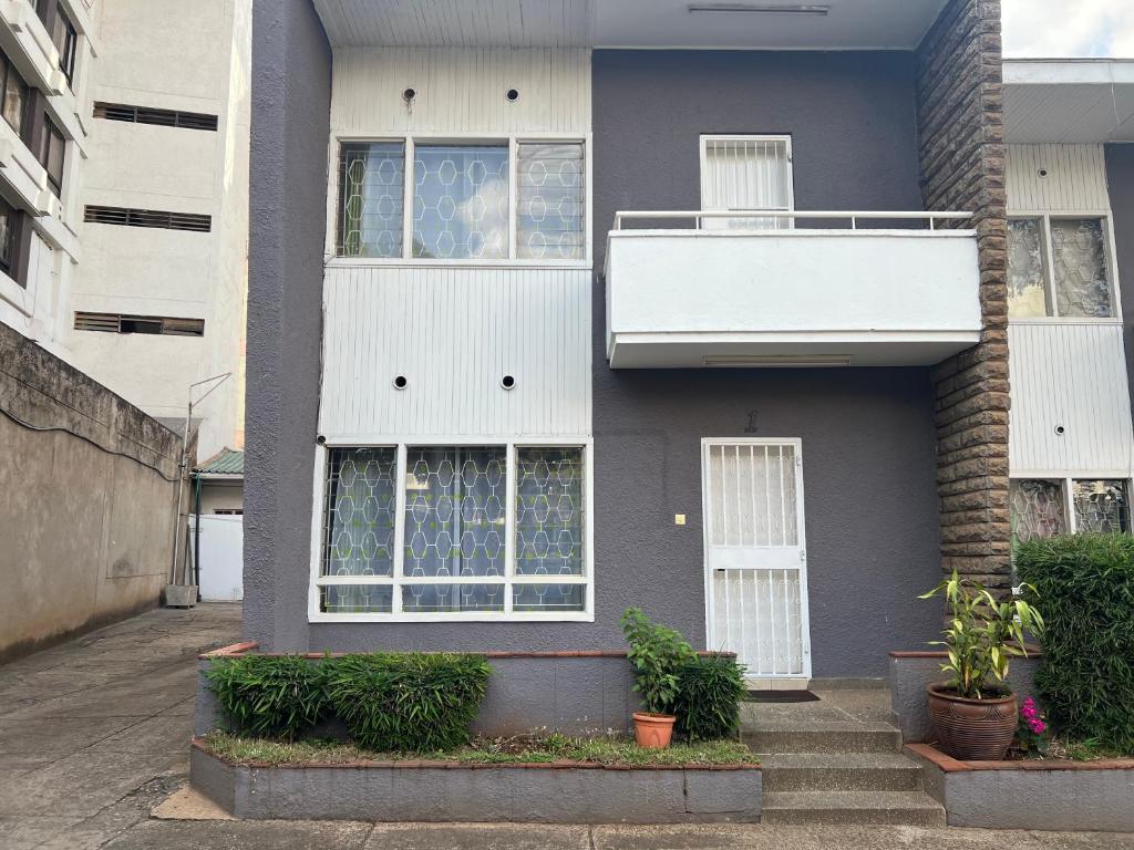 a gray house with white windows and a balcony at Juke's Serene Westlands Villa in Nairobi
