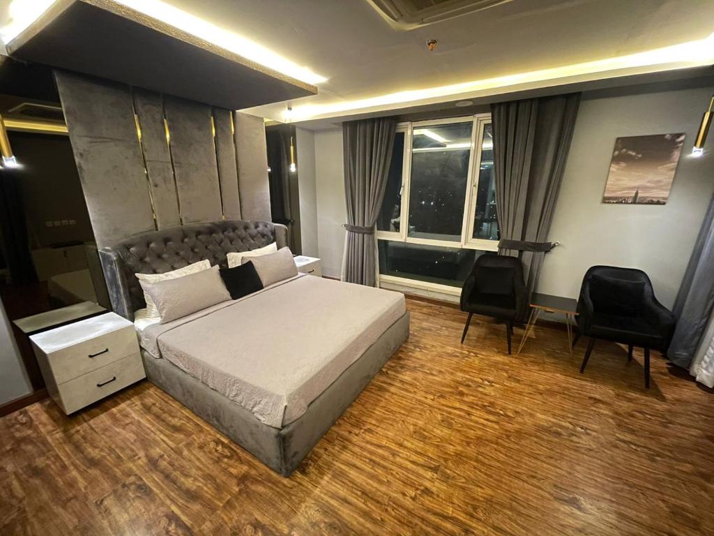1 dormitorio con cama, escritorio y ventana en Luxury one bed Apartment in Gold Crest Mall And Residency DHA Lahore en Lahore