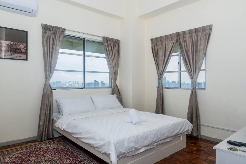 1 dormitorio con 1 cama con sábanas blancas y ventanas en MyRehat Puncak Anthenauem 3 Bedroom, en Kuala Lumpur