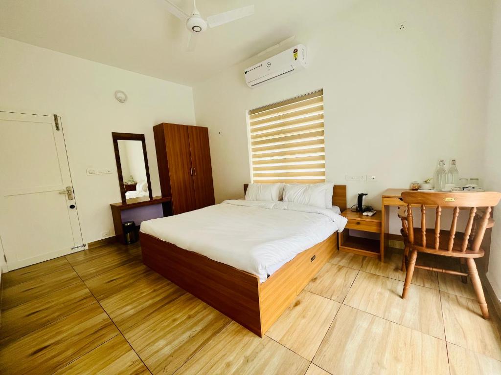 a bedroom with a bed and a desk and a chair at NIRVANA HAVEN HOME STAY in Trivandrum