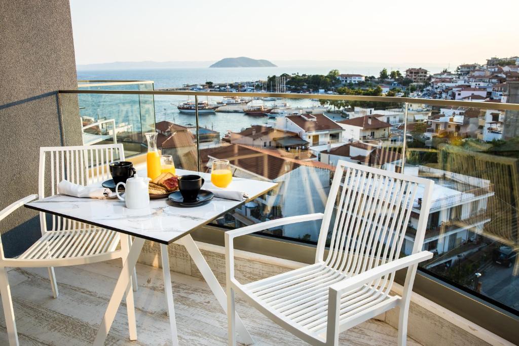 einen Tisch und Stühle auf einem Balkon mit Aussicht in der Unterkunft Kali Thea Suites in Neos Marmaras