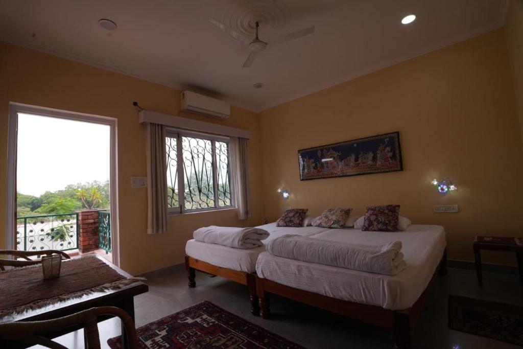 - une chambre avec 2 lits et une fenêtre dans l'établissement lalita homestay countryside, à Khajurâho