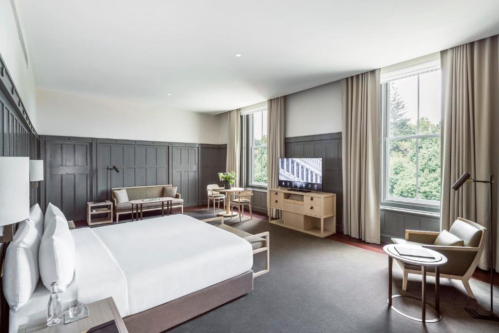 a hotel room with a bed and a television at COMO The Treasury in Perth