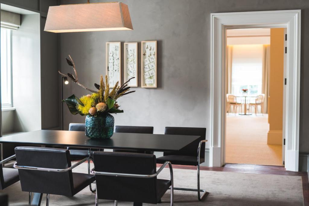 a dining room with a black table and chairs at COMO The Treasury in Perth