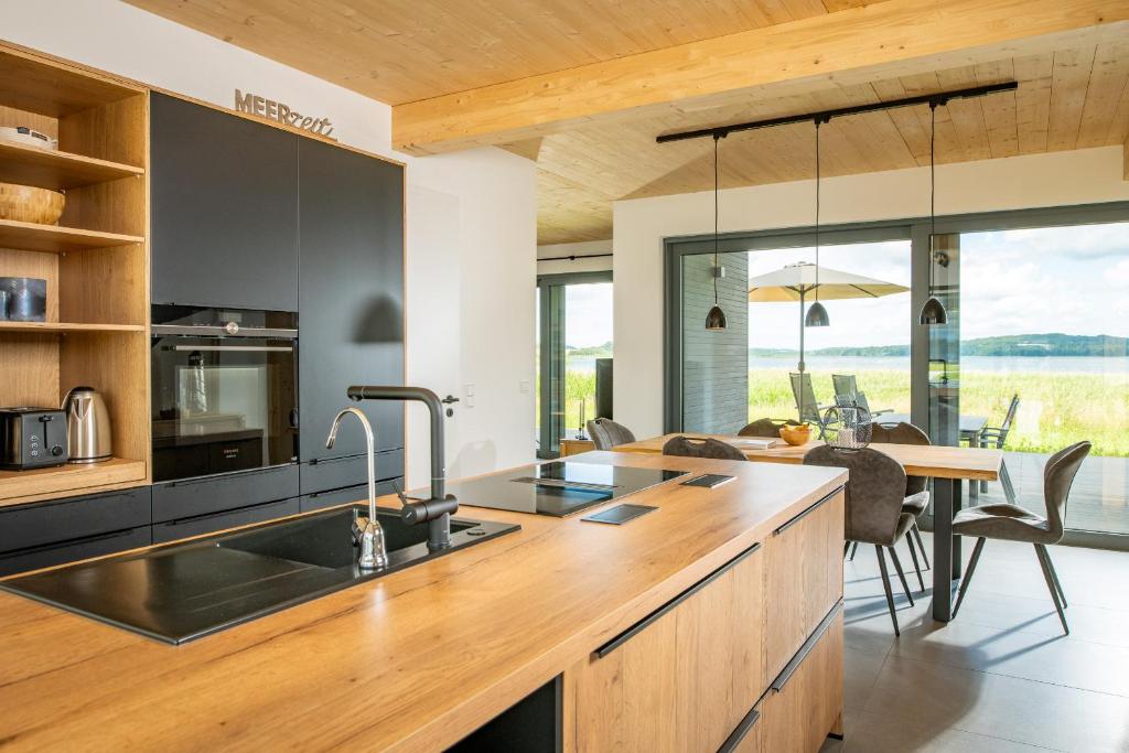 a kitchen with a sink and a table with chairs at LUV - Haus am See in Streu
