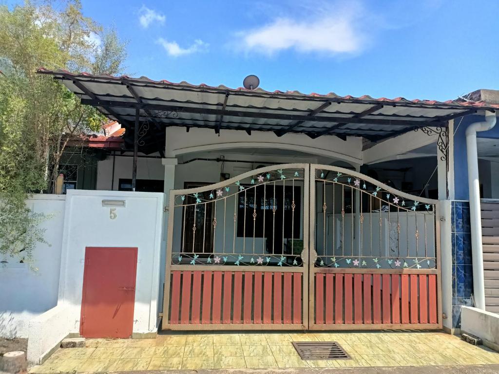 a gate to a house with a red door at Leeza Homestay in Kampung Kempadang