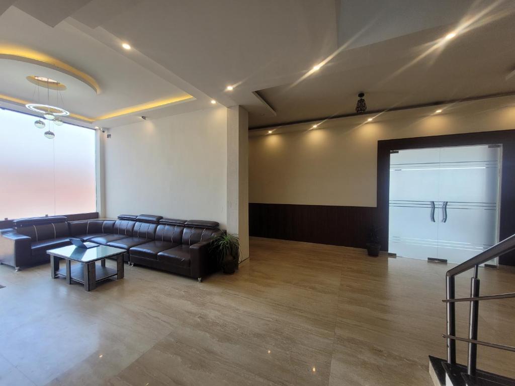 AyodhyaNeelkanth Hotel的一间带皮沙发和车库门的大房间