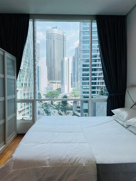 a large bed in a room with a large window at SOHO Suites KLCC in Kuala Lumpur