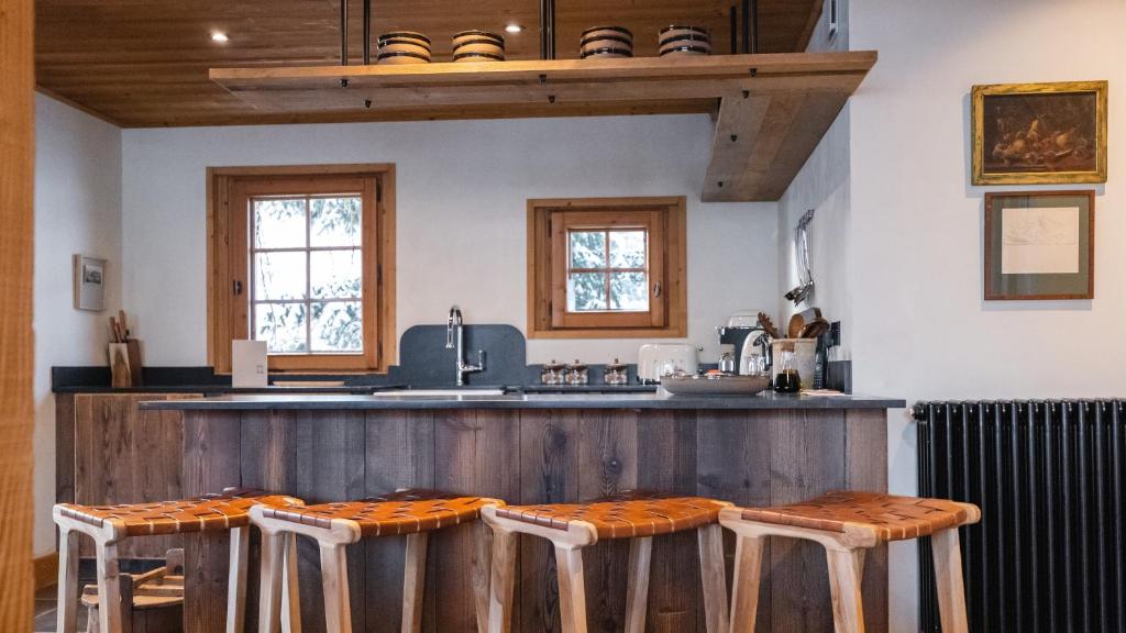 a kitchen with a counter with stools at L'Alpaga, a Beaumier hotel in Megève