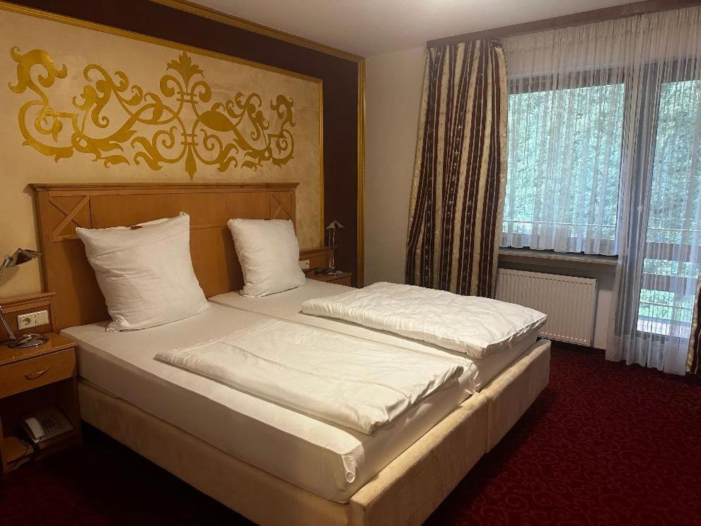 a bedroom with two beds and a window at Breitbacher Hof in Waldbreitbach