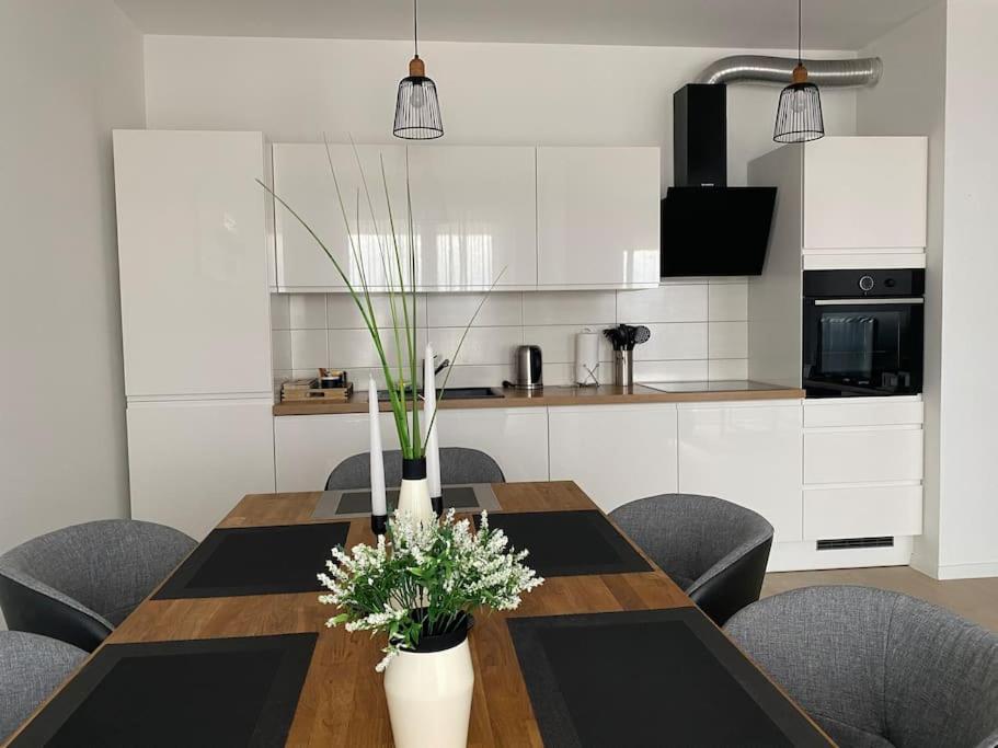 a dining room table with chairs and a kitchen at New modern APT near Old town - private parking in Zadar