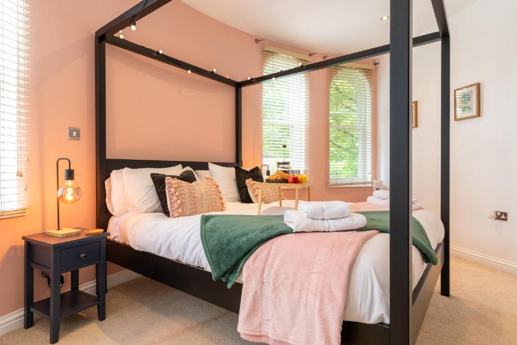 two beds in a bedroom with a large canopy bed at 3-Bedroom Lower Ground Flat in Knaresborough Town Centre in Knaresborough