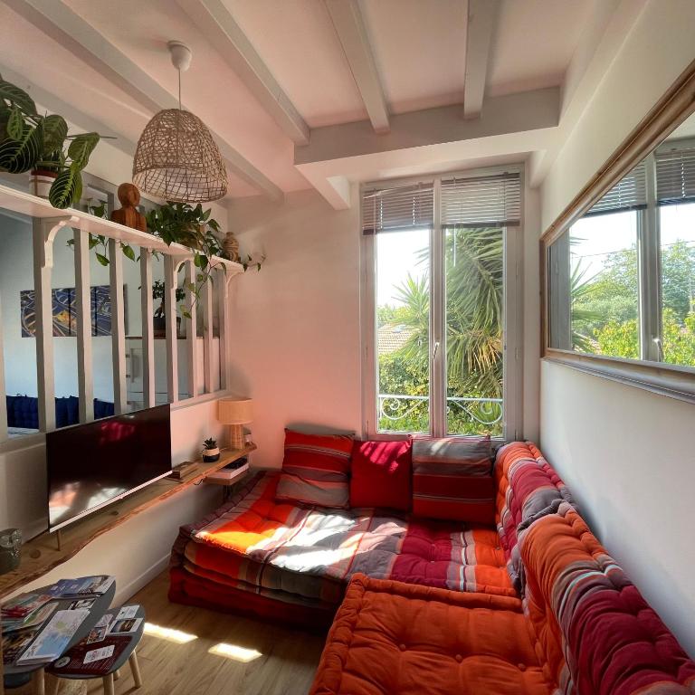 a living room with a couch and a tv at La Chouette du lac Marion in Biarritz