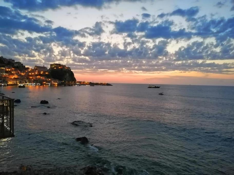 una vista del océano al atardecer con una ciudad en Balcone sul mare, en Scilla