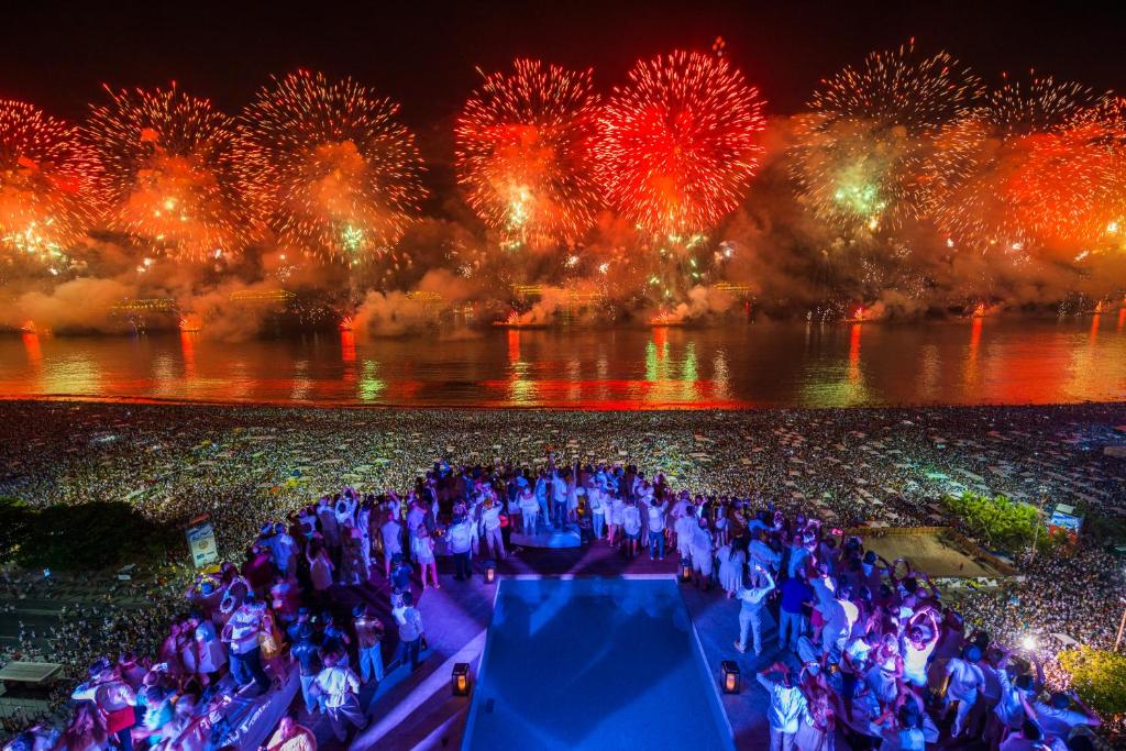 a group of people on a boat with fireworks at PortoBay Rio de Janeiro in Rio de Janeiro