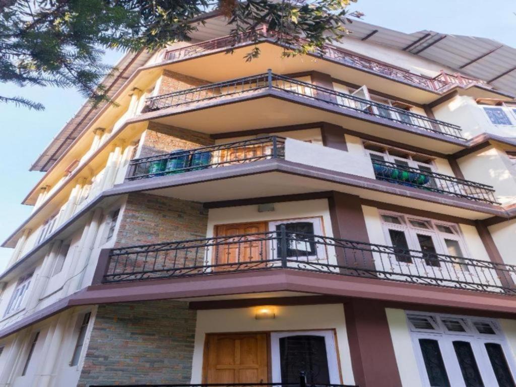 ein hohes Gebäude mit Balkonen darüber in der Unterkunft Stay Inn Belle Vue House in Shillong