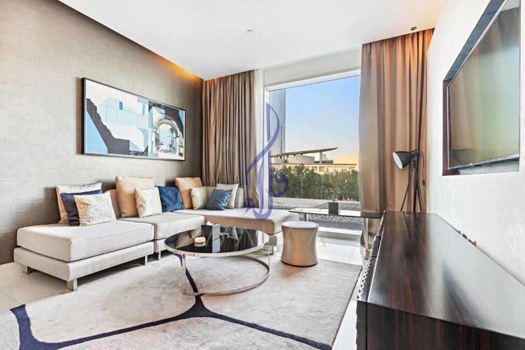 Walaa Homes Stylish 1BR at DAMAC Esclusiva tower Riyadh-M07 في الرياض: غرفة معيشة مع أريكة وطاولة