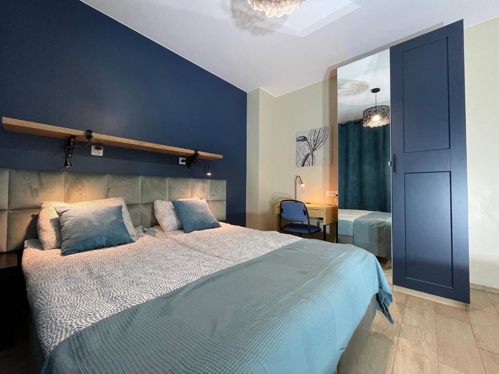 - une chambre avec un grand lit et un mur bleu dans l'établissement Superior Baltea 3 rooms, Beach 800m, AirCondition, à Gdańsk