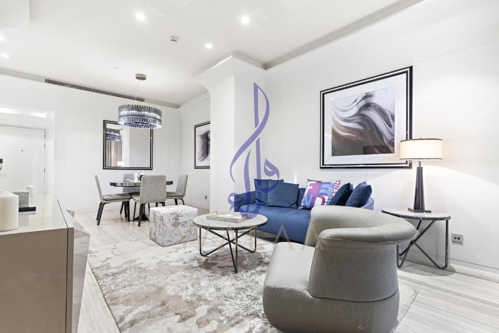 een woonkamer met een blauwe bank en een tafel bij Walaa Homes Luxury 1BR at DAMAC Esclusiva Tower Riyadh-M03 in Riyad