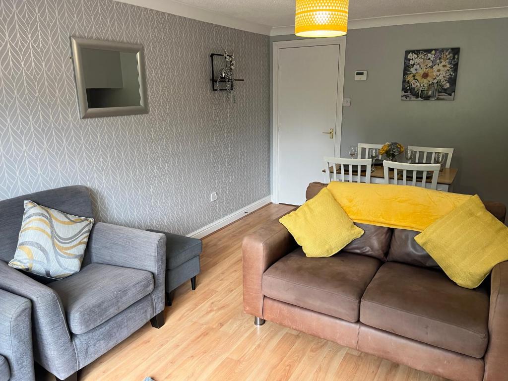 uma sala de estar com um sofá e uma cadeira em Claygate Place - Modern 2 Bed House with Parking em Nottingham