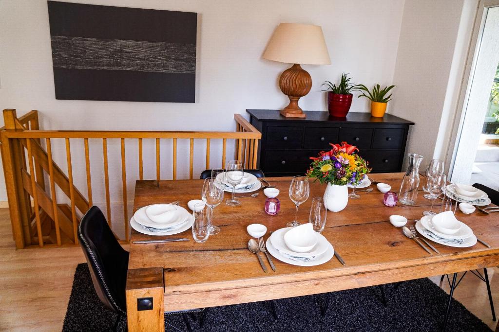 un tavolo in legno con piatti e bicchieri e fiori di Zug Zugersee Lake- and Mountainview House with charm a Zugo