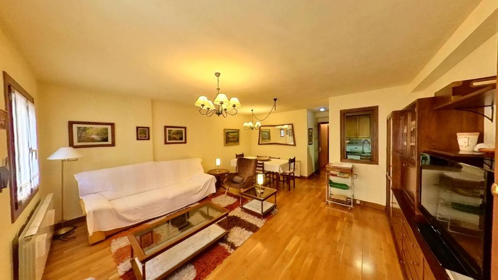 a living room with a white couch and a table at El Llano de Escarrilla - tucasaenlospirineos in Escarrilla