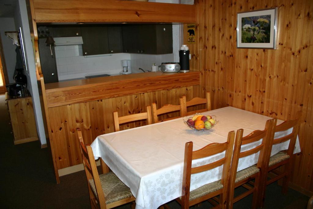 un comedor con una mesa con un bol de fruta. en Mayens de l'Ours MOUNTAIN & CENTER apartments by Alpvision Résidences, en Agettes