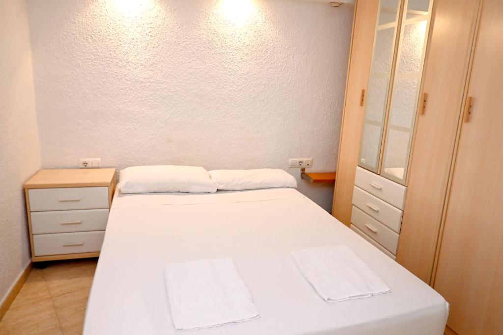a small bedroom with a white bed and a dresser at Homenfun Barcelona Sagrada Familia Glories in Barcelona