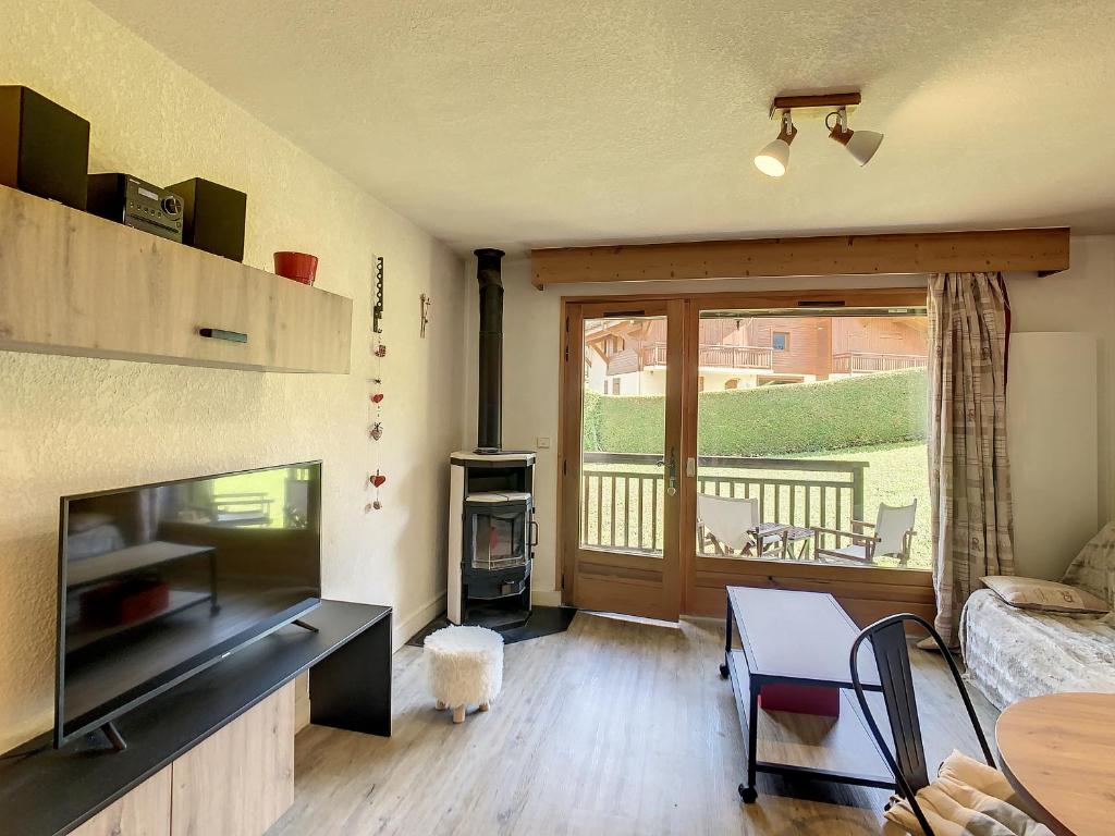 salon z telewizorem i salon ze stołem w obiekcie Charmant 2P à Combloux avec terrasse, parking et casier à ski - FR-1-560-101 w mieście Combloux