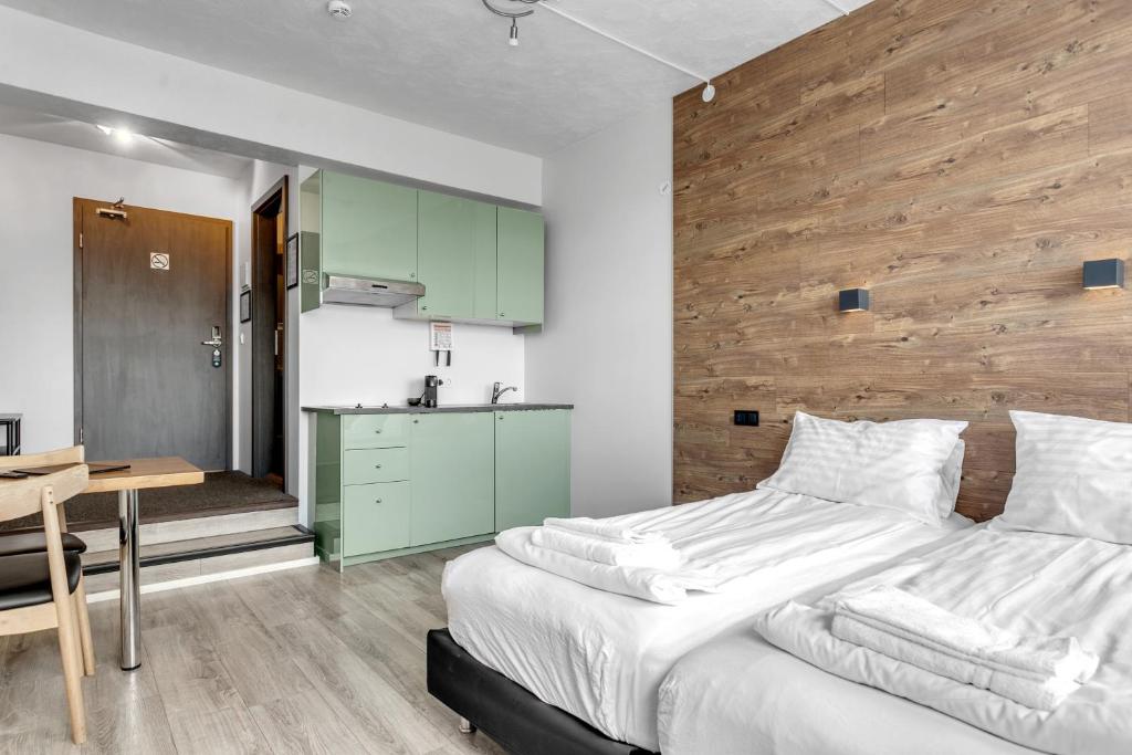 1 dormitorio con 1 cama grande y pared de madera en Stay Apartments Bolholt, en Reikiavik