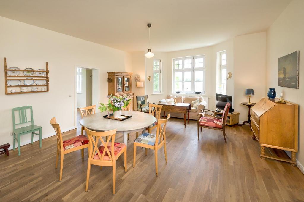 a dining room and living room with a table and chairs at Ferienwohnung 3 mit gr Terrasse und Wasserblick in Neuenkirchen