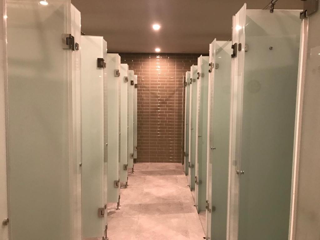 a row of stalls in a bathroom with a hallway at PassGo Digital Airport Terminal 2 Soekarno Hatta in Rawabagol