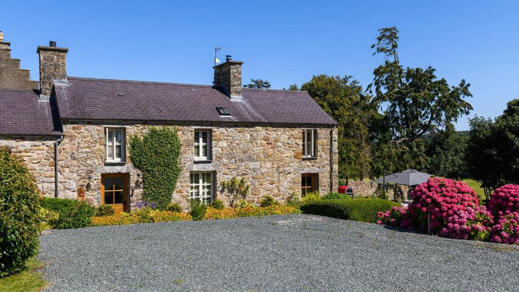 a large stone house with a gravel driveway at 5 Bodafon Country Estate in Penrhos-Lligwy